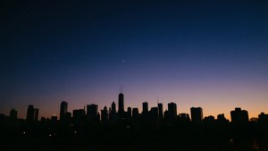 暮色中的城市天際線，漸變天空中有星星可見
