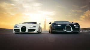 兩輛Bugatti超級跑車在沙漠公路上相對，背景是夕陽下的哈利法塔。 — 布加迪 壁紙