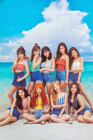 九位穿著夏季服裝的年輕女性在陽光明媚的海灘上快樂地擺姿勢。
