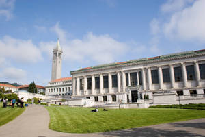 學生們在有鐘樓的歷史悠久大學建築附近的草地上放鬆。