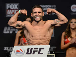UFC拳手在稱重活動中展示手臂，啦啦隊在後方。