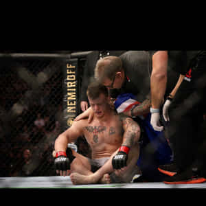 一名落敗的MMA拳手在八角籠內接受醫護人員治療。