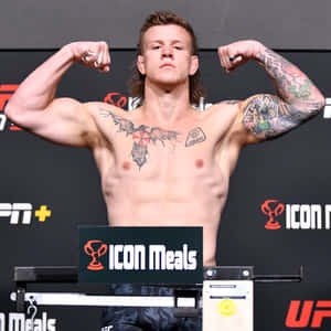 一位有紋身的 UFC 拳手在過磅活動中在磅秤上展示肌肉。 — 搏擊會 GIF 壁紙