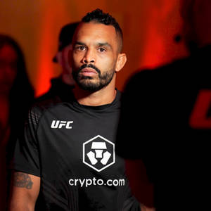 UFC拳手在室內活動中穿著crypto.com襯衫，處於紅燈下
