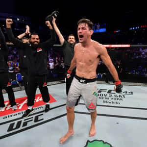 UFC拳手與團隊在八角籠中慶祝勝利。