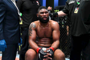 比賽後筋疲力竭的UFC拳手坐在八角籠中。