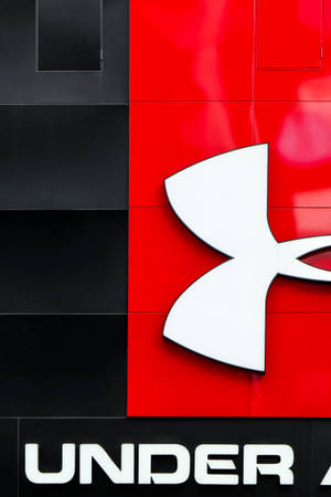 紅色和黑色瓷磚牆上的 Under Armour 標誌
