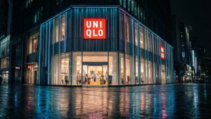 夜晚Uniqlo角落建築，霓虹燈反射在濕漉漉的人行道上