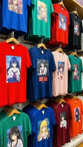 色彩繽紛的動漫角色T恤掛在木衣架上的商店展示。