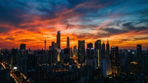 密集城市上空戲劇性的日落，閃爍的摩天大樓和條紋雲