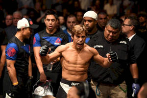 UFC拳手在八角籠內高舉雙臂慶祝勝利。