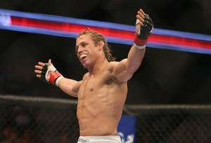 MMA選手在八角籠中高舉雙臂慶祝勝利。
