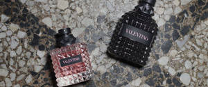 兩瓶 Valentino 香水放在斑點石面上。