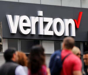 行人走過 Verizon 商店標誌。