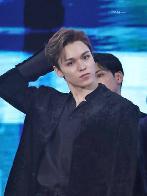 年輕表演者身穿黑色外套在藍色燈光舞台上演唱會 — Brandon lee GIF 壁紙