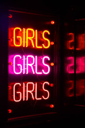 霓虹燈牌，上面有「girls」字樣重複三次，顏色發光。