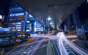 天橋下的夜間城市高速公路，車輛行駛留下的光軌。