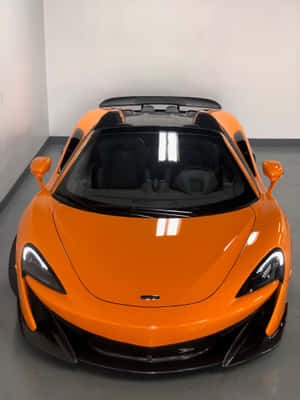 橙色McLaren跑車配黑色車頂停放在室內 — iPad 第9代 壁紙
