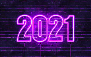 夜間在黑暗磚牆上顯示2021的紫色霓虹標誌。