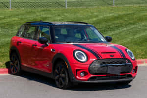 紅色MINI Cooper S帶黑色條紋停在瀝青路上，靠近草地。 — 夏天 壁紙