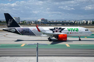 Viva Aerobus飛機在停機坪上，帶有馬刺隊標誌，天空多雲