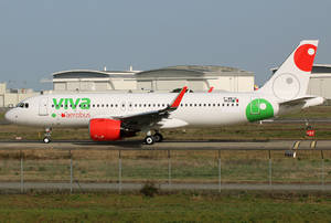 Viva Aerobus飛機在機場跑道上滑行，背景有機庫。