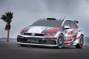福士Polo GTI拉力賽車停在柏油路上，旁邊有棕櫚樹，天空多雲。 — Surface Pro 壁紙