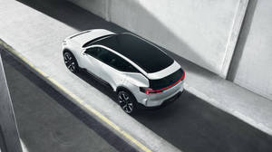 白色電動SUV，黑色車頂，停在混凝土坡道上。 — 汽車 壁紙