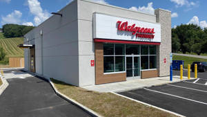 Walgreens藥房店面，設有停車場，背景是綠色山丘。