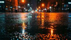 雨滴在濕漉漉的人行道上泛起漣漪，反射夜晚的城市燈光