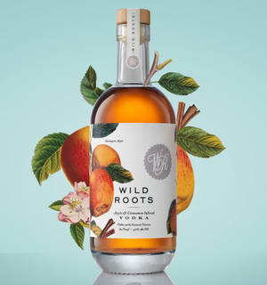 一瓶Wild Roots伏特加，帶有蘋果和肉桂圖案，周圍環繞著樹葉和花朵。 — Honor Magic V 壁紙