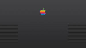 復古彩虹Apple標誌在深灰色筆記本電腦蓋上，帶通風槽。