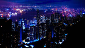 一個充滿活力的夜景城市，有發光的摩天大樓和燈火通明的海港。 — 夜景城市 壁紙