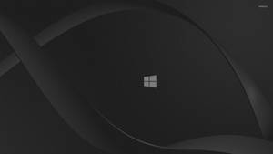 深灰色抽象背景，中央有Windows標誌和流動曲線。 — 視窗 壁紙