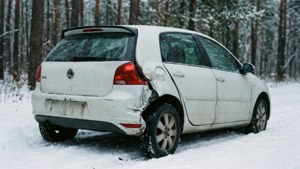 雪地森林中遺棄的損壞白色汽車