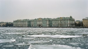 從結冰的河流對岸看到的宏偉宮殿，河上有破碎的浮冰和積雪。