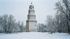 古塔上積滿雪，周圍是光禿禿的冬季樹木。
