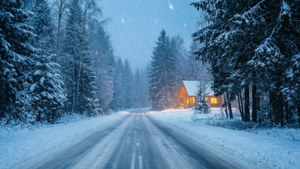 一條雪路通往冬季森林中一間帶有溫暖燈光的舒適小屋。