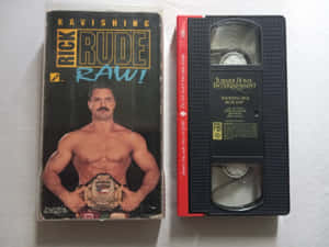 Ravishing Rick Rude Raw! 的VHS錄影帶和盒子， featuring 摔角手持有冠軍腰帶。 — 摔角 GIF 壁紙
