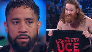 摔角手拿著「Honorary UCE」襯衫，對手專注地看著。 — 摔角 GIF 壁紙