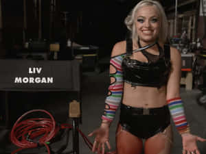 摔角手 Liv Morgan 身穿閃亮黑色服裝配彩色袖，喺後台。