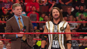 WWE 旁述員和摔角手在擂台上，紅色繩索後面有歡呼的人群。