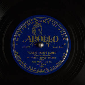 特寫鏡頭：一張復古Apollo Records黑膠唱片標籤，藍色背景配金色文字。