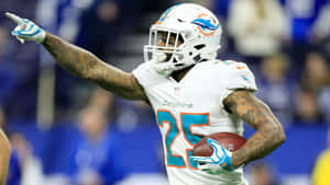 邁阿密海豚隊25號球員拿著足球並做出指向手勢慶祝。 — NFL 美式足球 GIF 壁紙