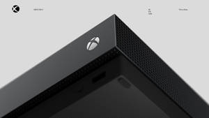 時尚黑色 Xbox One X 主機角落，帶有銀色標誌和穿孔紋理。
