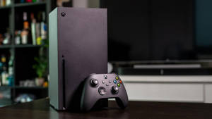 客廳木桌上的黑色 Xbox Series X 主機和手掣。