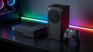 兩部 Xbox 主機和手掣放在一張有彩色 LED 燈的桌子上。