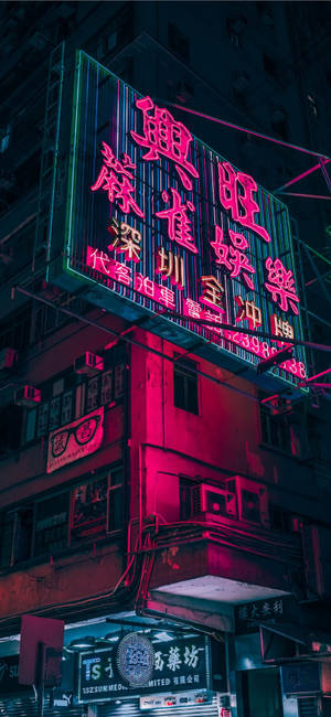 霓虹燈在夜間用粉紅色和綠色的燈光照亮城市建築。