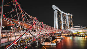 螺旋橋在夜間亮燈，背景為濱海灣金沙