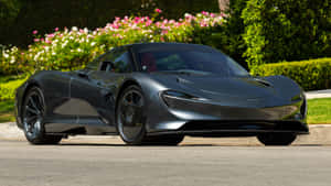 啞光灰色McLaren Speedtail停泊在盛開的粉紅色和白色花朵旁邊。 — 4K 法拉利 壁紙